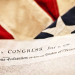 close up of the Declaration of Independence and American flag