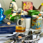 trinkets and dishware with price tags for garage sale