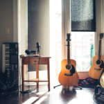 room with two guitars and piano keyboard