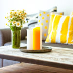 colorful pillows on a couch with candles and flowers