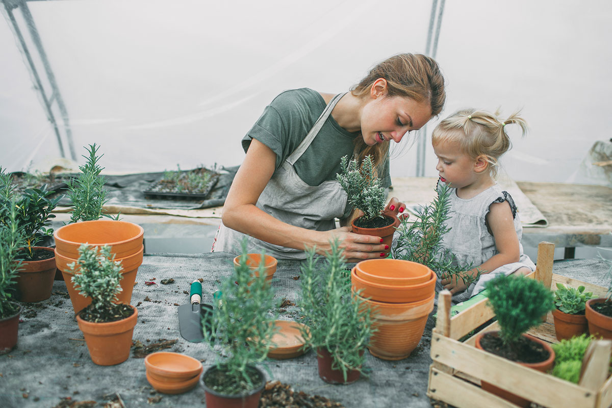 image of a mother and daughter gardening with potted plants