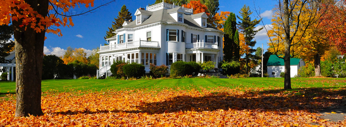 a mansion with a bunch of leaves on the ground
