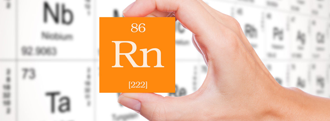 A person holding a periodic table square of Radon