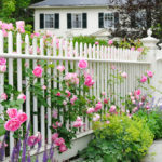 white picket fence covered in pink flowers
