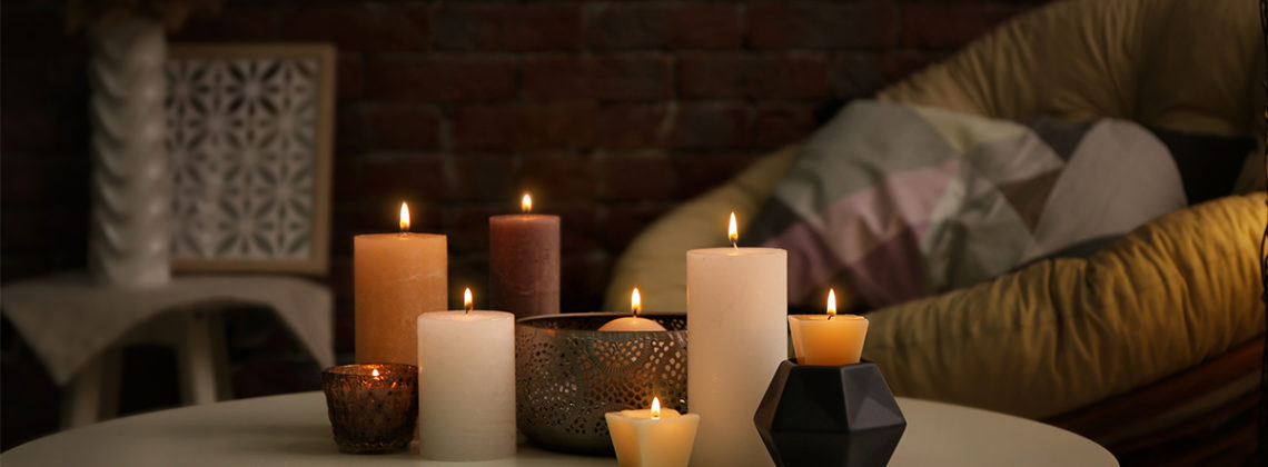 several candles are lit on a cozy coffee table