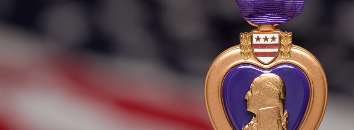 purple heart medal with blurred american flag background