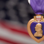 purple heart medal with blurred american flag background
