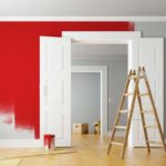 freshly painted red wall with ladder in foreground