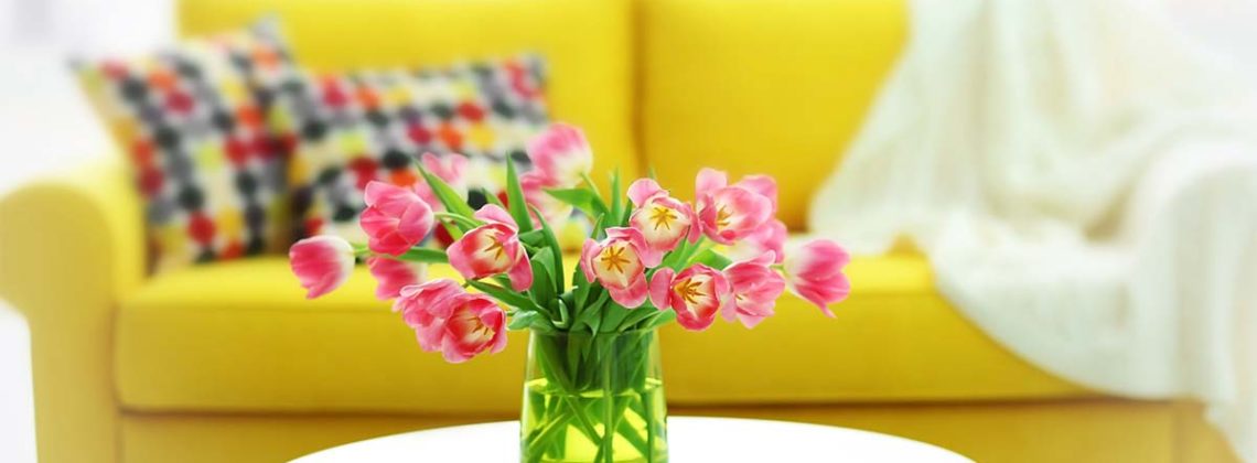 tulips in vase with yellow couch in background