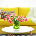 tulips in vase with yellow couch in background