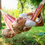 two young brothers swing in a hammock