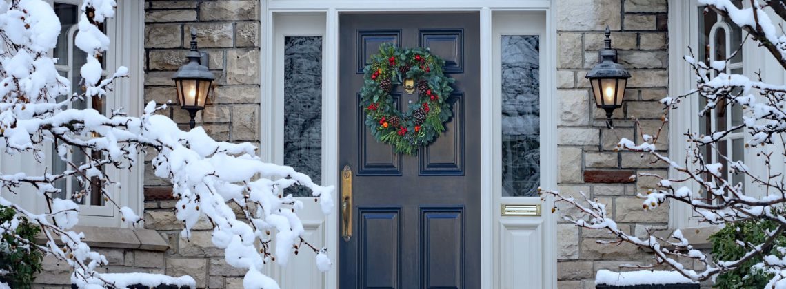 Winter doorway, snow in trees, wreath on house door