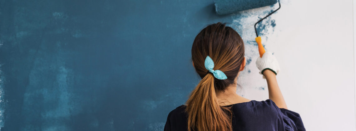 woman painting a wall blue