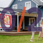 Real estate agent shaking hands with clients in front of a home with a SOLD sign
