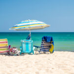 Beach chairs and an umbrella on the sand in front of the ocean